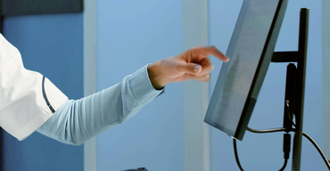A practitioner reviewing the Doctena Pro dashboard alongside their existing practice software.
