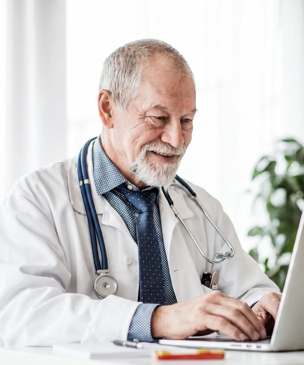 Een zorgverlener beheert zijn planning op een laptop