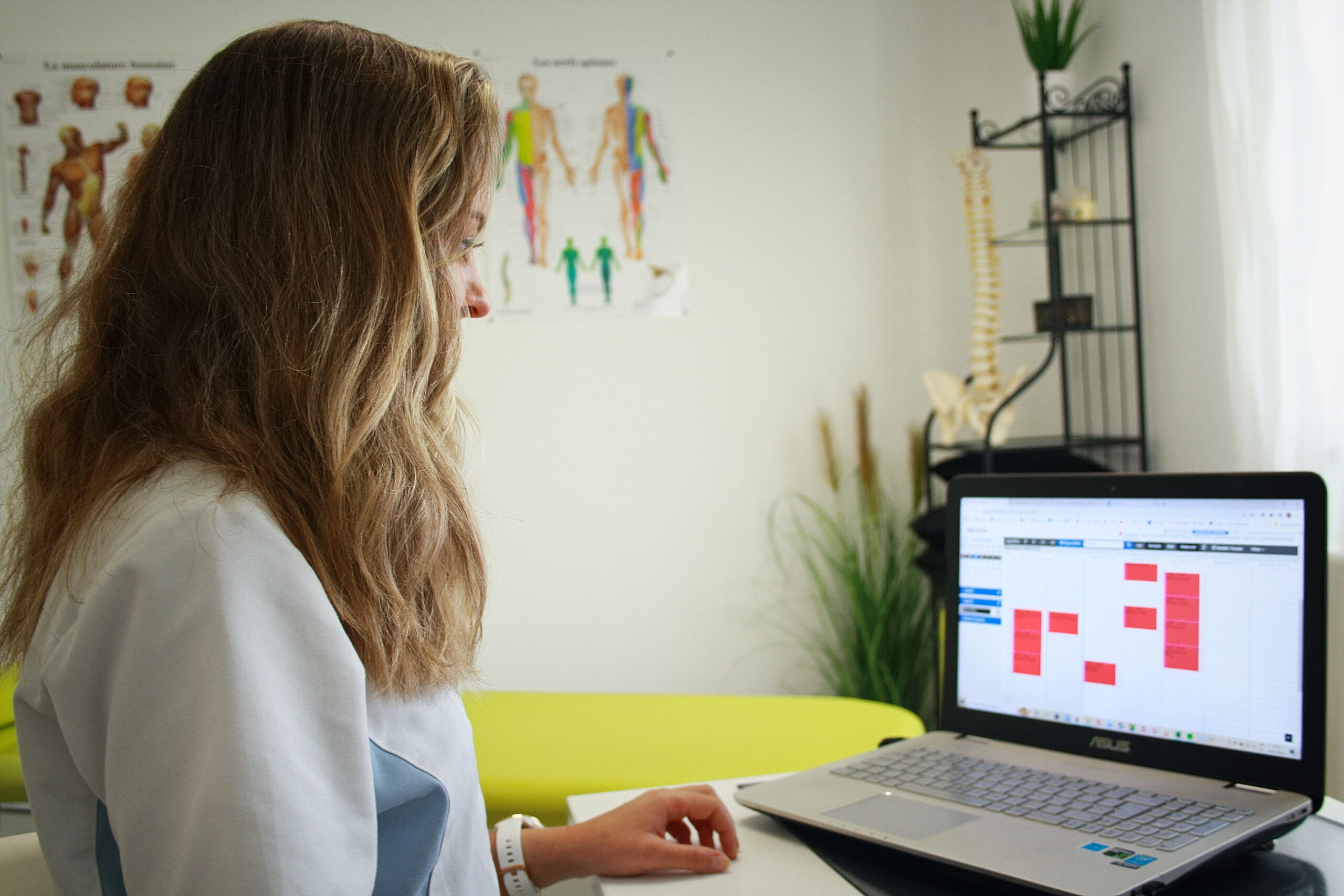 Elise Mosca bekijkt haar online agenda op een laptop in haar praktijk